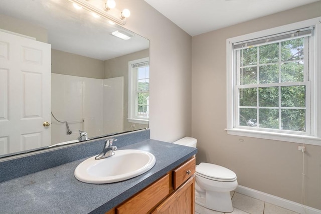 bathroom with plenty of natural light, toilet, tile patterned flooring, and vanity