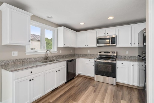 kitchen featuring stainless steel appliances, hardwood / wood-style flooring, sink, and white cabinets