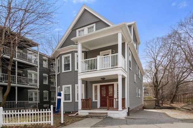 view of front of home with a porch, crawl space, french doors, a balcony, and aphalt driveway