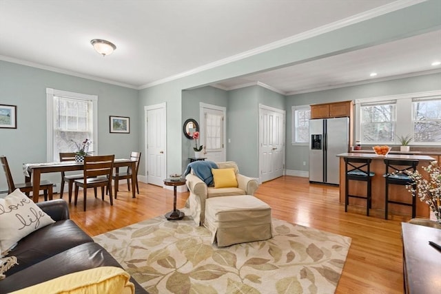 living room with baseboards, a wealth of natural light, and light wood-style floors