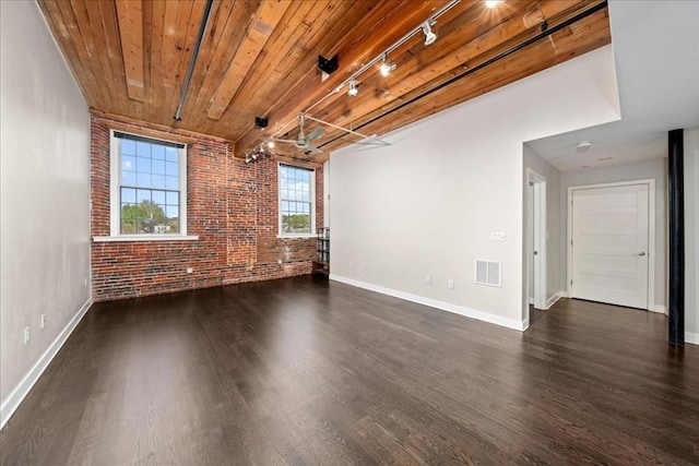empty room with wooden ceiling, baseboards, brick wall, visible vents, and dark wood-type flooring