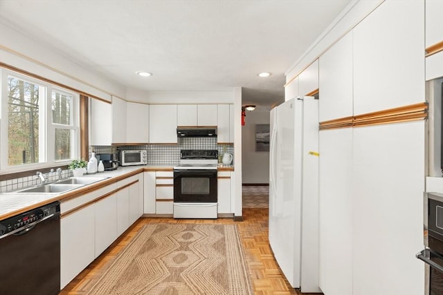 kitchen with range with electric cooktop, a sink, black dishwasher, light countertops, and freestanding refrigerator