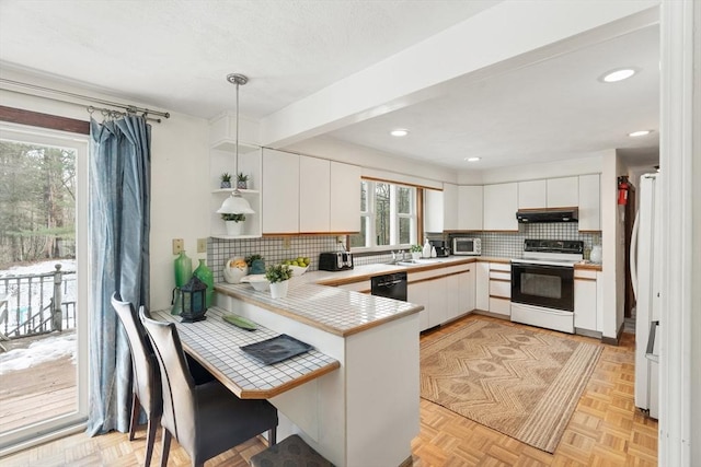 kitchen with electric range oven, white cabinets, a peninsula, dishwasher, and under cabinet range hood