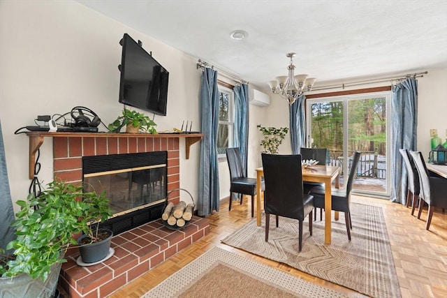 dining space with a chandelier, a wall mounted air conditioner, and a brick fireplace