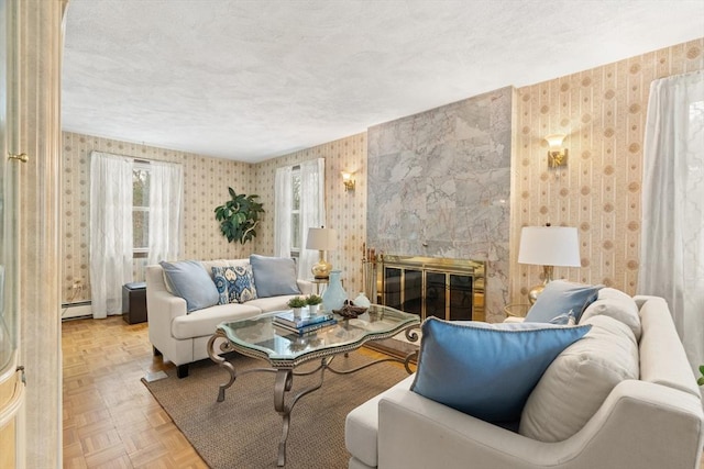 living room featuring wallpapered walls, a baseboard heating unit, a textured ceiling, and a tile fireplace