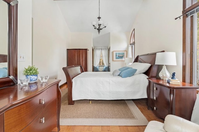 bedroom with vaulted ceiling and a notable chandelier