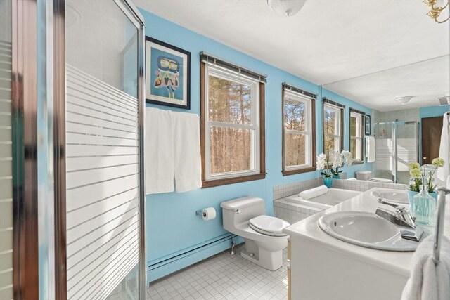 bathroom featuring toilet, baseboard heating, a stall shower, a sink, and tile patterned floors