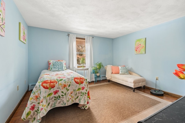 bedroom featuring baseboards, baseboard heating, and a textured ceiling