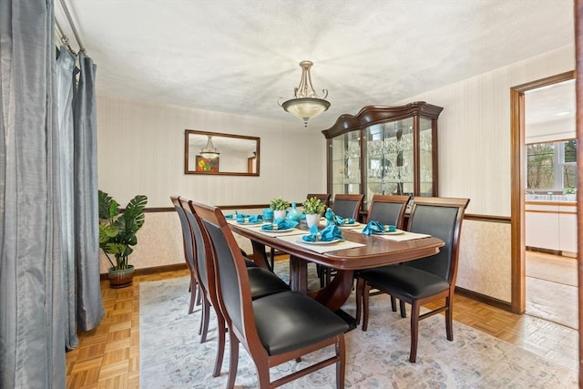 dining space with a textured ceiling and baseboards