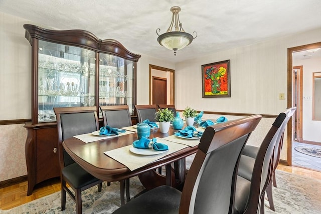 dining room featuring baseboards and wallpapered walls