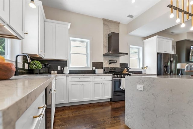 10 Wakefield Ave Unit A, Wakefield, MA 01880 - kitchen featuring stainless steel appliances, wall chimney exhaust hood, plenty of natural light, and white cabinetry