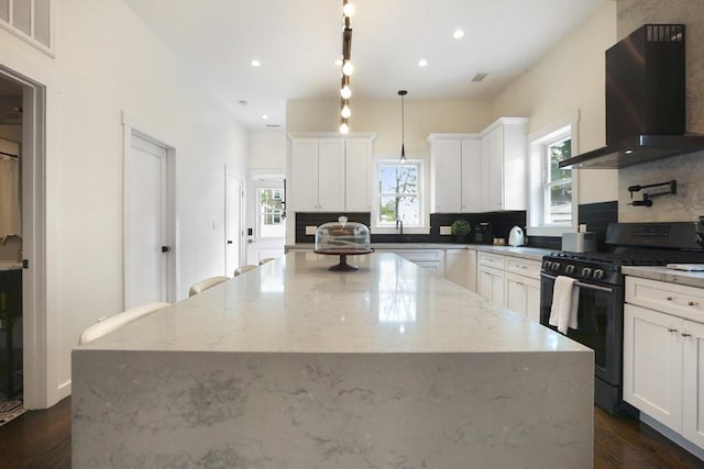 10 Wakefield Ave Unit A, Wakefield, MA 01880 - kitchen with black gas stove, ventilation hood, a kitchen island, decorative backsplash, and dark wood-type flooring