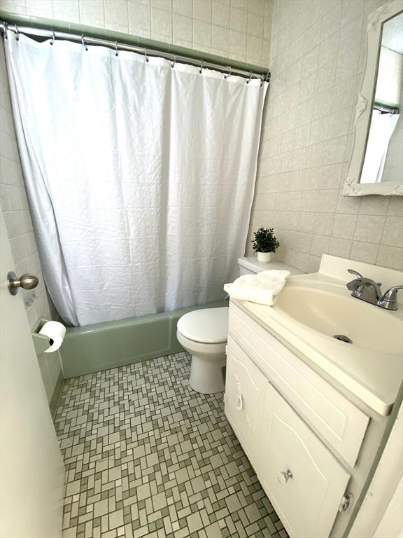 101 Adams St, Newton, MA 02458 - full bathroom with vanity, shower / bath combo, and tile walls