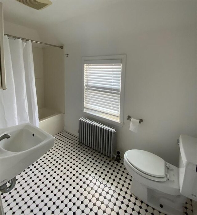 full bathroom featuring radiator, shower / bathtub combination with curtain, and toilet