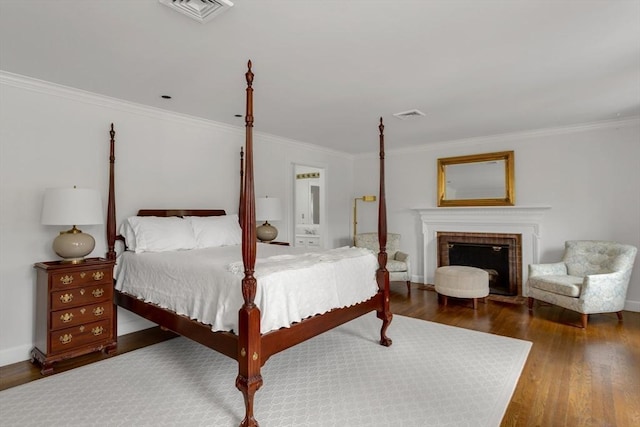 bedroom featuring a fireplace, dark hardwood / wood-style floors, and crown molding