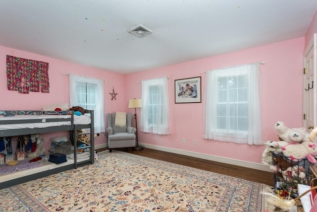 bedroom with multiple windows and hardwood / wood-style floors