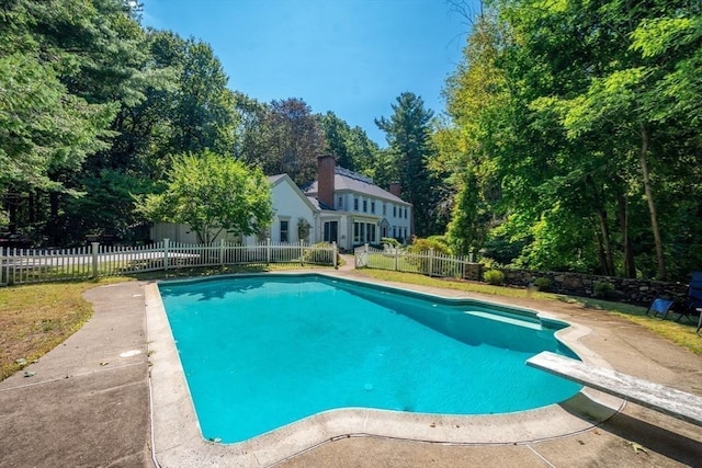 view of swimming pool featuring a diving board