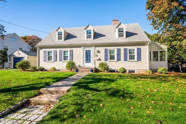 cape cod house featuring a shingled roof, a chimney, and a front lawn