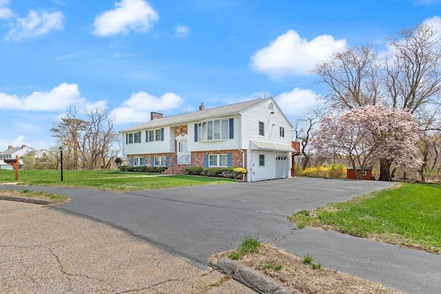 11 Ocean View Dr, Gloucester, MA 01930 - raised ranch with an attached garage, a chimney, asphalt driveway, a front yard, and brick siding