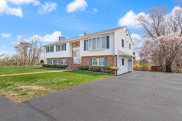 11 Ocean View Dr, Gloucester, MA 01930 - bi-level home with a chimney, brick siding, asphalt driveway, and a front yard