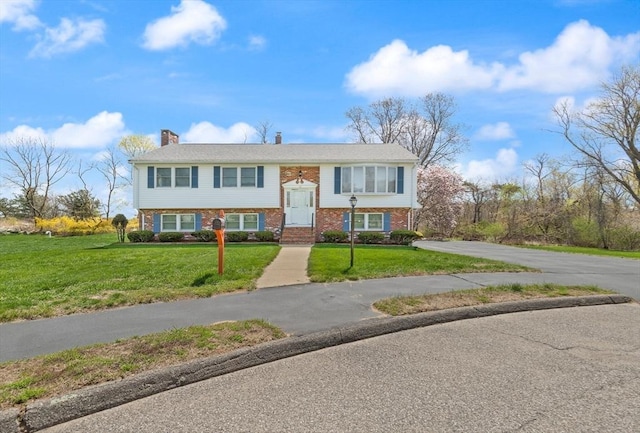 11 Ocean View Dr, Gloucester, MA 01930 - bi-level home with a front lawn, brick siding, driveway, and a chimney