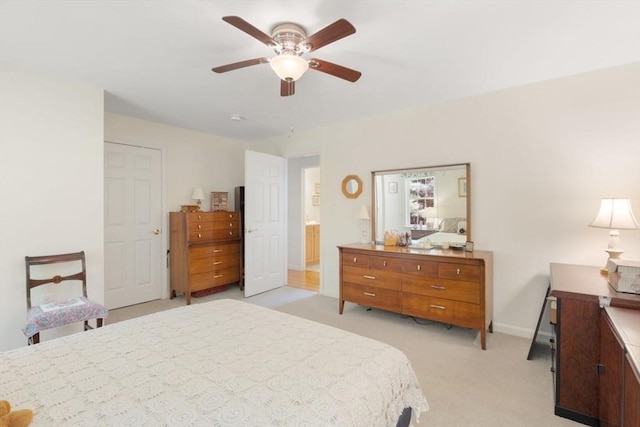 bedroom with light colored carpet, baseboards, and a ceiling fan