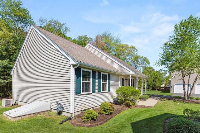 view of side of property featuring a yard, central air condition unit, and roof with shingles