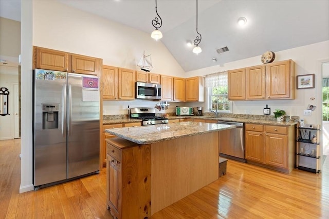 kitchen featuring appliances with stainless steel finishes, high vaulted ceiling, a sink, a kitchen island, and light stone countertops