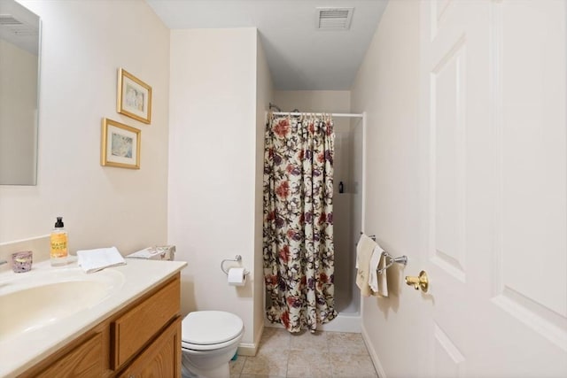 bathroom with a stall shower, toilet, vanity, tile patterned floors, and baseboards