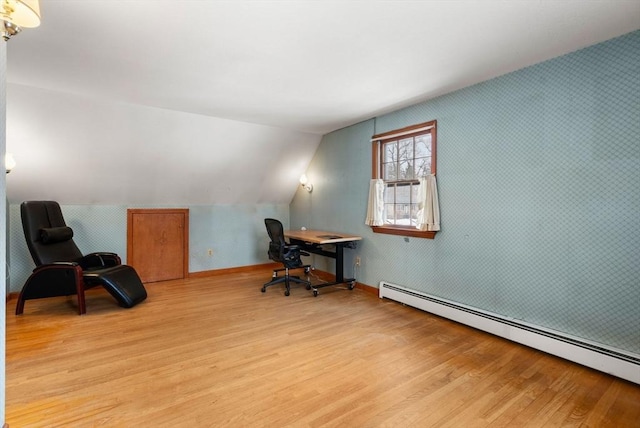 office with light wood finished floors, lofted ceiling, baseboard heating, baseboards, and wallpapered walls