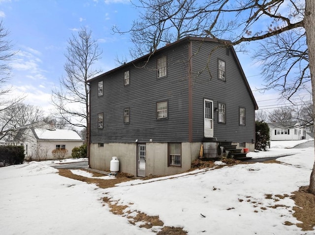 snow covered property featuring entry steps