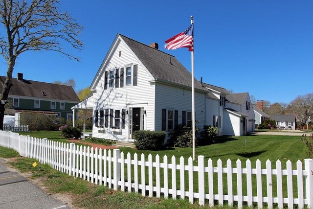 1243 Main St Unit 1243, Barnstable, MA 02635 - view of front facade with a front yard, a fenced front yard, and a chimney