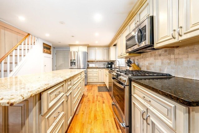 1243 Main St Unit 1243, Barnstable, MA 02635 - kitchen featuring tasteful backsplash, a sink, light wood-style floors, stainless steel appliances, and cream cabinets