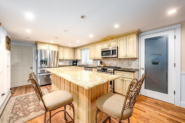 1243 Main St Unit 1243, Barnstable, MA 02635 - kitchen with cream cabinetry, stainless steel appliances, a baseboard heating unit, and a sink
