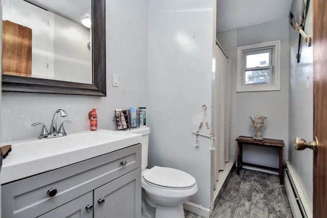 bathroom featuring a baseboard radiator, toilet, vanity, and curtained shower