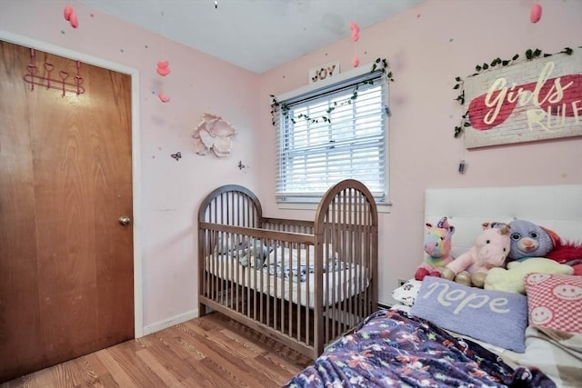 bedroom featuring wood finished floors and baseboards