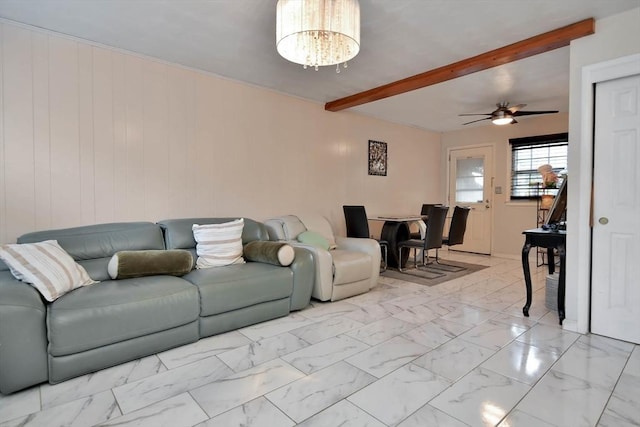 living room featuring beam ceiling, ceiling fan, marble finish floors, and a chandelier