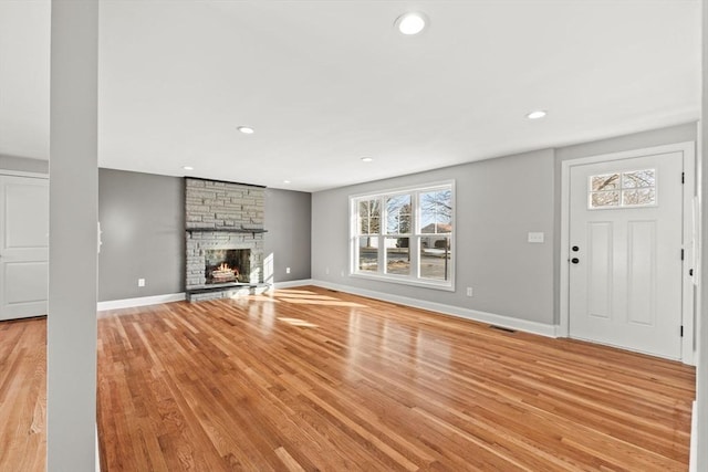 unfurnished living room featuring a fireplace and light hardwood / wood-style flooring