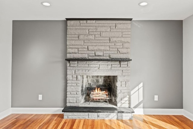 room details featuring hardwood / wood-style floors and a stone fireplace