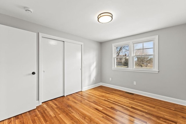 unfurnished bedroom featuring a closet and light hardwood / wood-style flooring