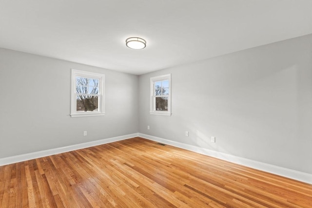 unfurnished room featuring hardwood / wood-style flooring and plenty of natural light