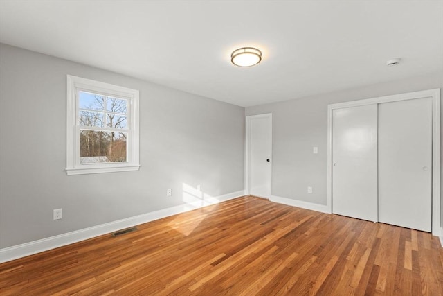 unfurnished bedroom with wood-type flooring and a closet