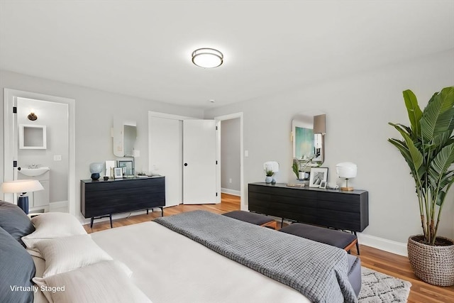 bedroom featuring ensuite bathroom and hardwood / wood-style floors