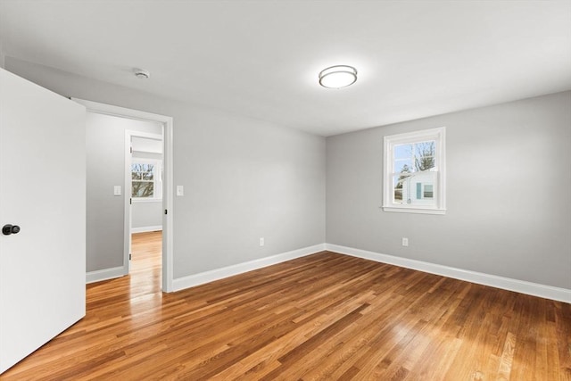 empty room with light hardwood / wood-style floors and a healthy amount of sunlight