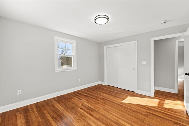 unfurnished bedroom with hardwood / wood-style flooring and a closet