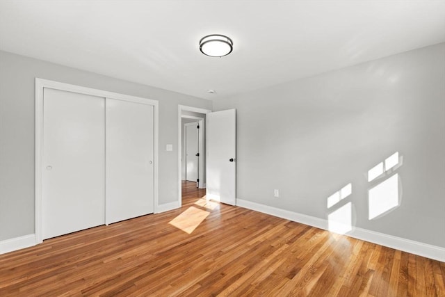 unfurnished bedroom with hardwood / wood-style floors and a closet