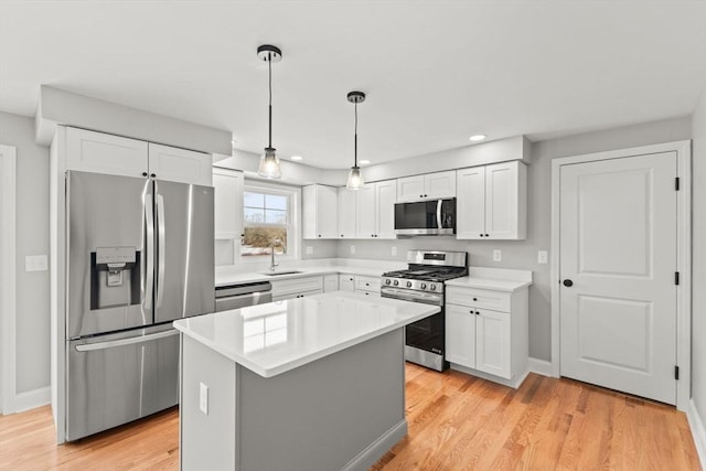 kitchen with pendant lighting, a center island, white cabinets, and appliances with stainless steel finishes