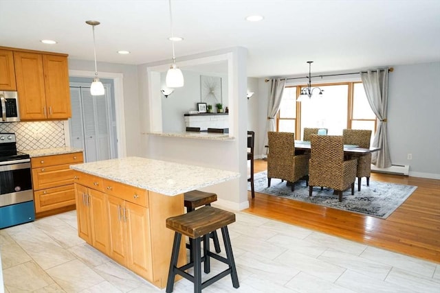 6 Sunrise, Auburn, MA 01501 - kitchen with stainless steel appliances, backsplash, a breakfast bar, a center island, and a baseboard heating unit