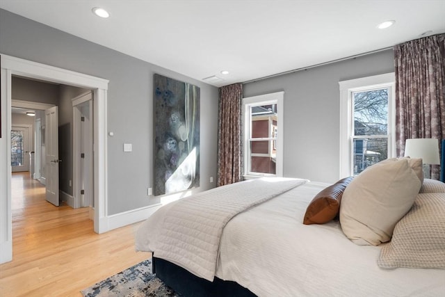 bedroom with baseboards, wood finished floors, and recessed lighting