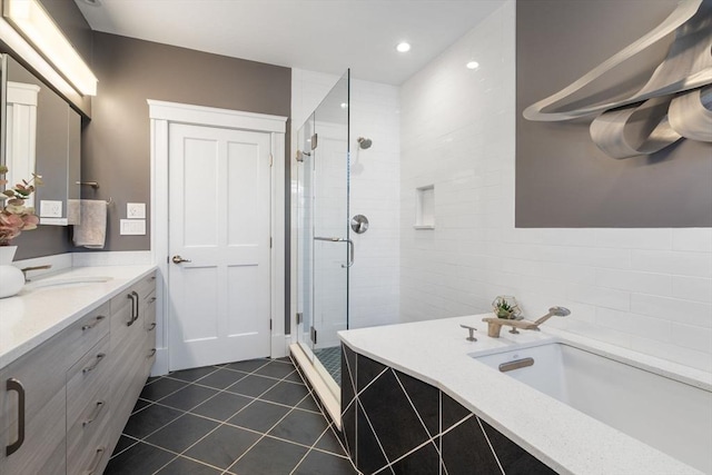 full bathroom featuring a stall shower, a garden tub, vanity, and tile patterned floors